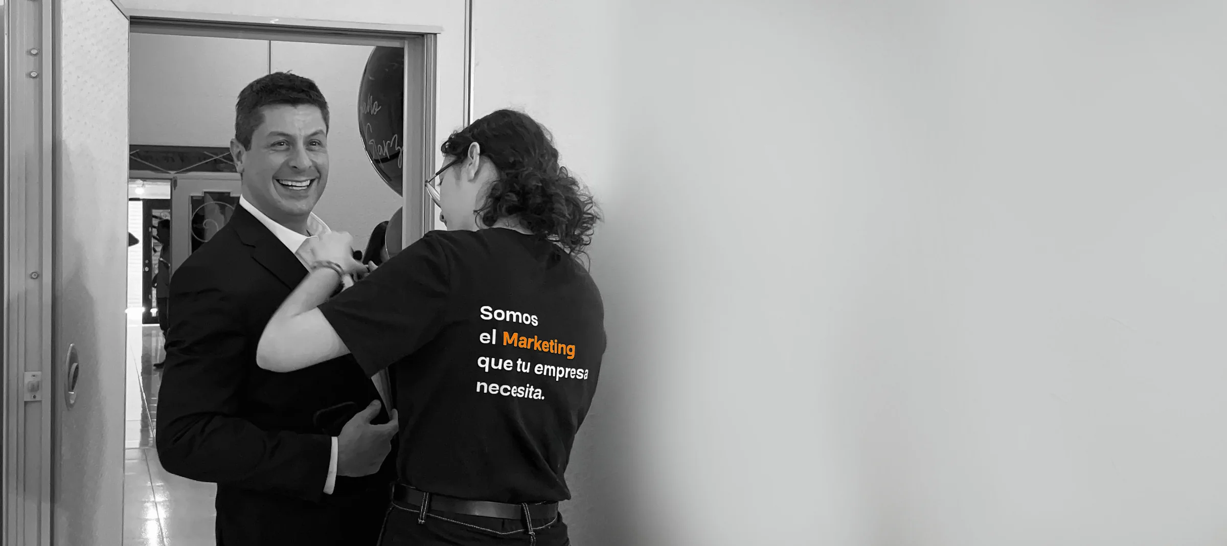 Viviana Campos atendiendo a un cliente que sonríe; su playera dice: somos el marketing que tu empresa necesita